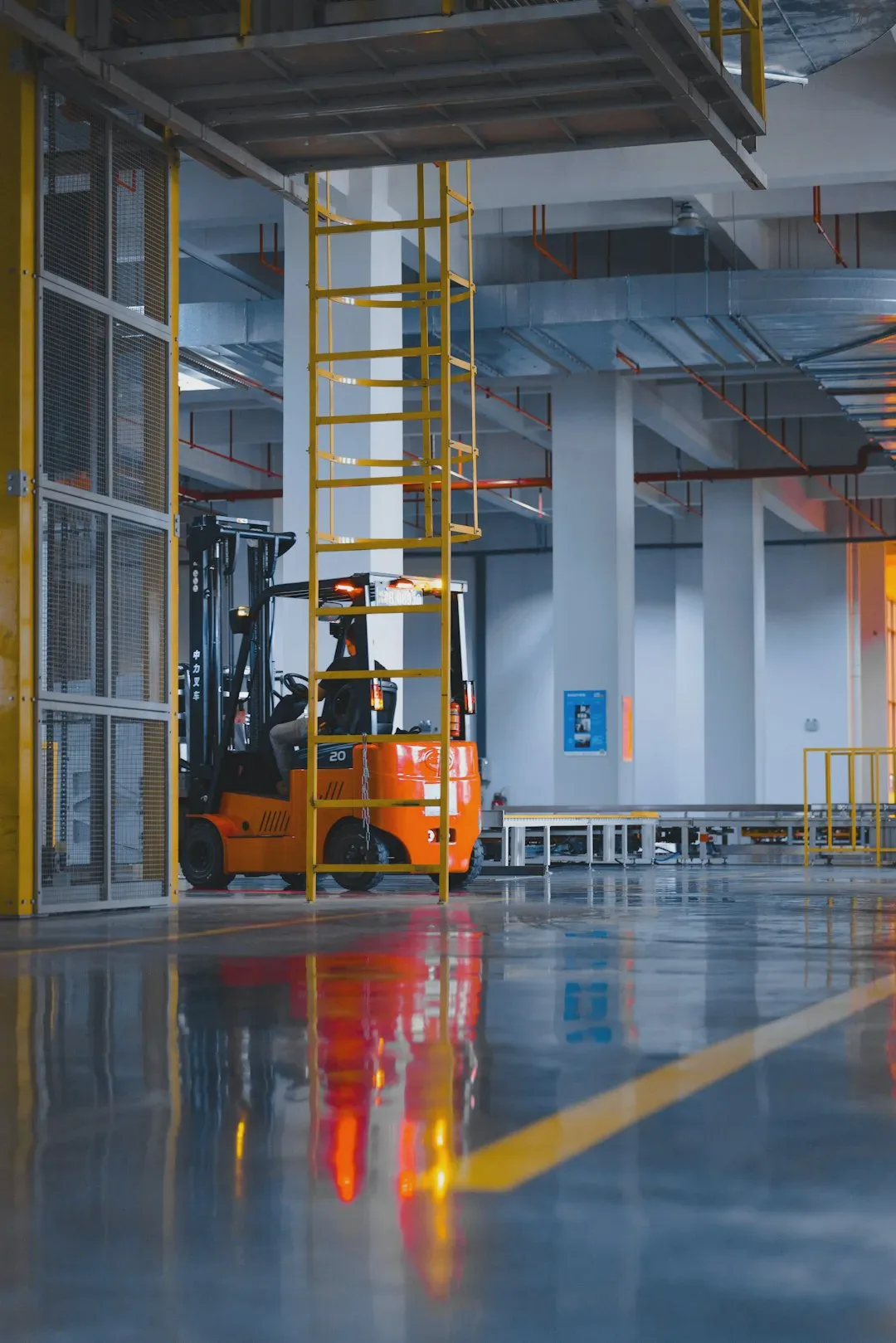 The photo shows a spacious industrial warehouse with a forklift and a yellow ladder visible. The surroundings are clean, orderly, and well lit, reflecting the professional character of the logistics operations. - Photo: Homa Appliances