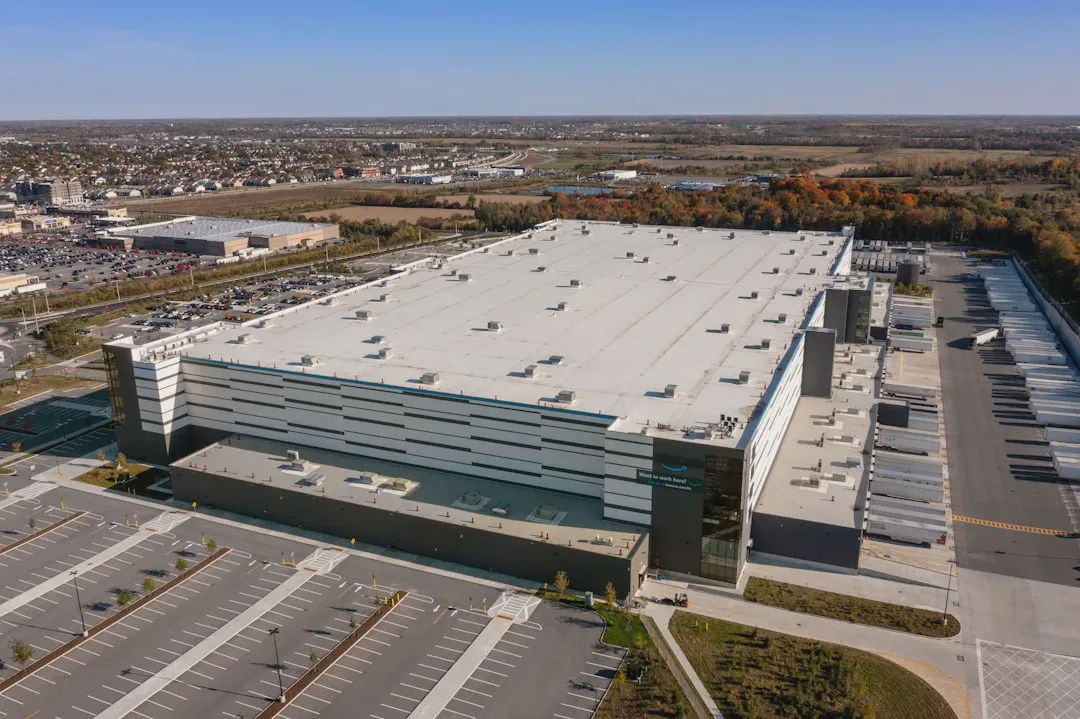 A large, modern warehouse complex with extensive parking areas and adjacent loading docks.